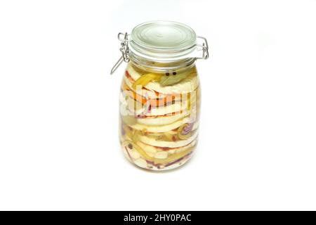 Plusieurs fromages de type camembert, oignons et poivrons marinés dans l'huile végétale dans une bouteille en verre. Isolé sur fond blanc. Banque D'Images