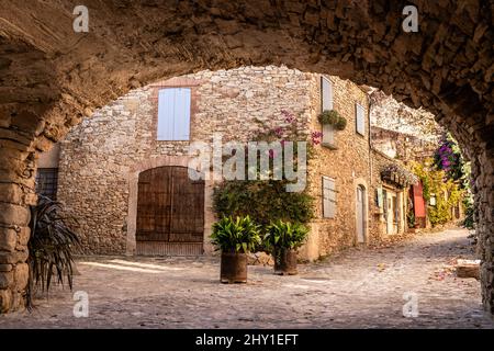 Ancien bâtiment en pierre avec des murs de merde rugueux et des plantes vertes le jour ensoleillé en Espagne Banque D'Images