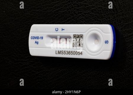Test de débit latéral positif Covid 19 / test de coronavirus d'antigène de débit latéral rapide sur fond noir montrant les deux barres sur la bandelette de test Banque D'Images