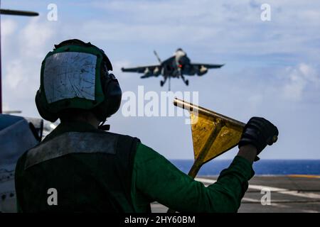 MER DES PHILIPPINES (13 mars 2022) Aviation Boatswain’s Mate (Equipment) Airman Vital Depina, de Boston, observe les opérations de vol sur le pont de vol du porte-avions USS Abraham Lincoln de la classe Nimitz (CVN 72). Abraham Lincoln Strike Group est en cours de déploiement prévu dans la zone d'exploitation de la flotte américaine 7th afin d'améliorer l'interopérabilité par le biais d'alliances et de partenariats tout en servant de force d'intervention prête à l'emploi pour soutenir une région Indo-Pacifique libre et ouverte. (É.-U. Photo de la marine par la spécialiste en communication de masse apprenti Julia Brockman) Banque D'Images