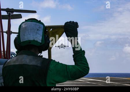 MER DES PHILIPPINES (13 mars 2022) Aviation Boatswain’s Mate (Equipment) Airman Vital Depina, de Boston, observe les opérations de vol sur le pont de vol du porte-avions USS Abraham Lincoln de la classe Nimitz (CVN 72). Abraham Lincoln Strike Group est en cours de déploiement prévu dans la zone d'exploitation de la flotte américaine 7th afin d'améliorer l'interopérabilité par le biais d'alliances et de partenariats tout en servant de force d'intervention prête à l'emploi pour soutenir une région Indo-Pacifique libre et ouverte. (É.-U. Photo de la marine par la spécialiste en communication de masse apprenti Julia Brockman) Banque D'Images