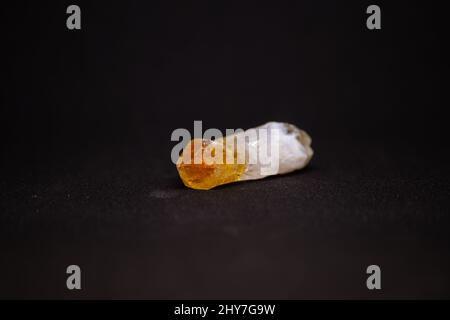 Gros plan d'une pierre de quartz citrine sur fond noir Banque D'Images