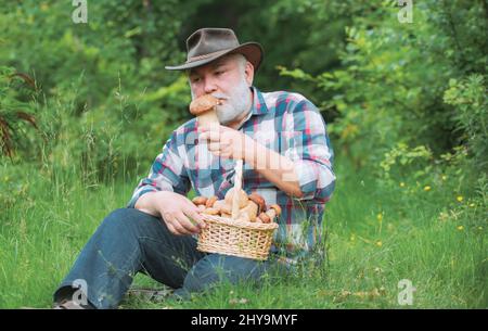Grand-père heureux - été et passe-temps. Grand-père pensionné. Grand-père avec panier de champignons et une expression faciale surprise. Banque D'Images
