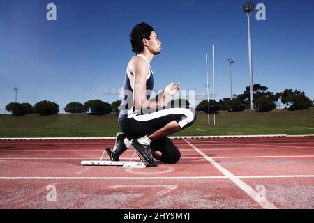 Se débarrasser de son esprit avant une course. Un jeune athlète se prépare à commencer une course. Banque D'Images