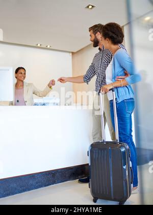Votre chambre devrait être prête. Photo d'un jeune couple qui s'est fait enregistrer dans un hôtel. Banque D'Images