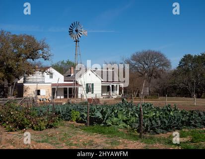 La ferme, le jardin, le réservoir d'eau et le moulin à vent de la ferme Sauer-Beckmann Living History Farm au parc national Lyndon B. Johnson près de Stonewall, Texas. Banque D'Images