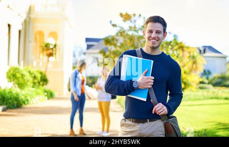 Ma mission est terminée, maintenant pour la remettre. Portrait d'un étudiant universitaire de sexe masculin à l'extérieur du campus. Banque D'Images