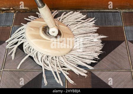 Vue d'une vadrouille de nettoyage usagée avec micro-fibres sur sol en céramique dans une maison. Banque D'Images