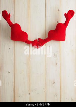Gros plan de coeurs doux avec deux mains isolées sur fond rustique en bois Banque D'Images