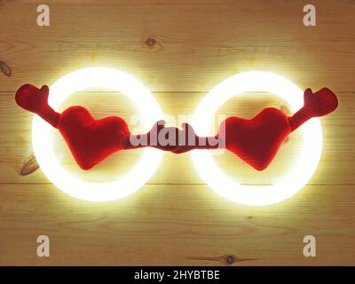 Gros plan de coeurs doux avec deux mains isolées sur fond rustique en bois Banque D'Images