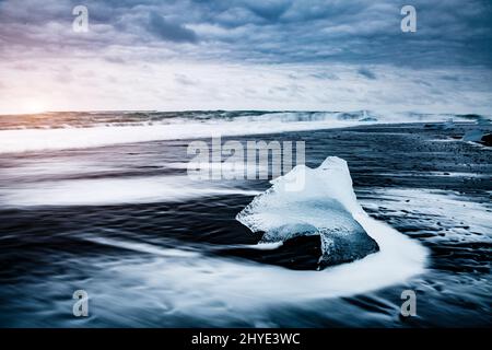 Les gros morceaux de l'iceberg qui brillent sur le sable noir. Scène magnifique et pittoresque. Emplacement endroit célèbre lagon Jökulsárlón, Vatnajokull nati Banque D'Images