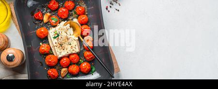 Fromage feta cuit au four avec tomates cerises, cuisine fetapasta. Vue de dessus, espace de copie. Banque D'Images