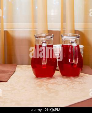 Deux cruches en verre de jus de canneberge sur la table. Banque D'Images