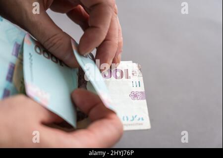 Gros plan des mains d'hommes comptant de l'argent. Un homme adulte compte les billets ukrainiens. Espèces en coupures de 1 000 hryvnias. Mise au point sélective. Banque D'Images