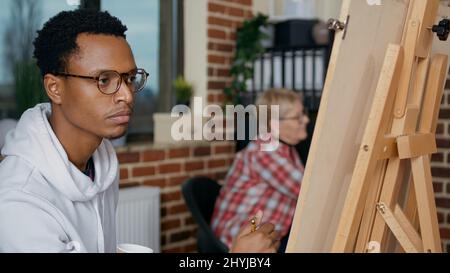Portrait d'un jeune étudiant utilisant un crayon sur toile pour dessiner un vase, apprenant des compétences créatives en classe d'art. Atelier artistique pour créer des dessins d'œuvres d'art avec de l'équipement de fabrication pour la croissance éducative. Banque D'Images