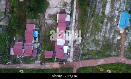 Vue aérienne des bâtiments de Kalimantan est à côté des champs agricoles. Banque D'Images