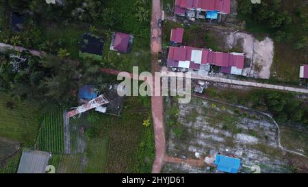 Vue aérienne des bâtiments de Kalimantan est à côté des champs agricoles. Banque D'Images