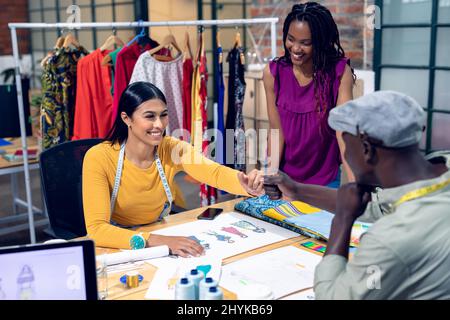 African american jeune femme designer à l'aspect multiracial jeune homme, femmes travailleurs faisant la fistump Banque D'Images