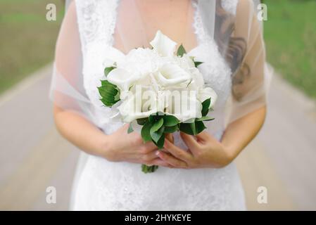 Bouquet de mariée de nénuphars blancs dans les mains de la mariée gros plan Banque D'Images