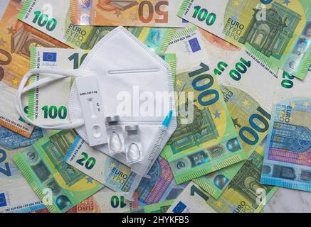 Argent (billets en euros) avec masque médical, test d'antigène, flacons de vaccin et seringue. Crise financière due aux pertes du coronavirus, sélective Banque D'Images