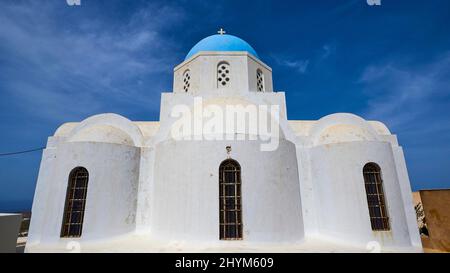 Grand angle, symétrique, arrière d'une chapelle orthodoxe à trois nef, toit en dôme bleu, ciel bleu avec nuages voile, Pyrgos, île de Santorini, Cyclades, Grèce Banque D'Images