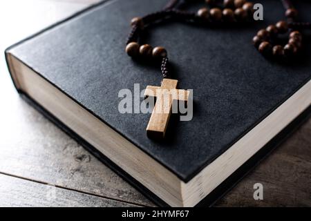 Croix catholique Rosaire sur holybible sur table en bois Banque D'Images
