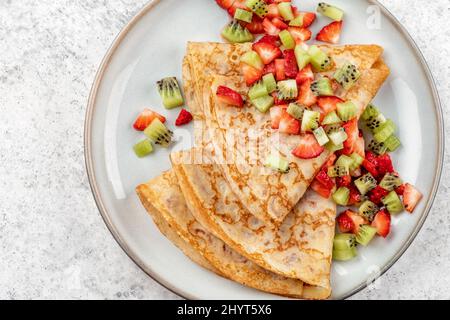 Crêpes saines aux fruits, kiwi et fraise. Petit déjeuner français sain Banque D'Images