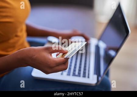 Un gros plan d'une jeune femme tenant une carte de crédit et faisant du shopping en ligne Banque D'Images