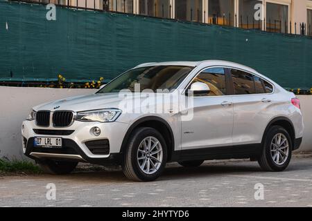 Side, Turquie - 18 février 2022 : La BMW blanche X5 est garée dans la rue par une chaude journée sur fond de rue Banque D'Images