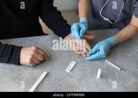 Infirmière effectuant un test pcr du coronavirus sur un homme âgé à la maison Banque D'Images