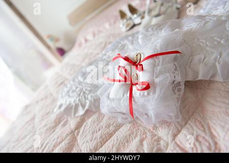 Gros plan sur des anneaux de désherbage avec des boucles rouges sur un tissu blanc Banque D'Images