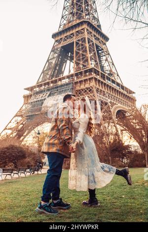 Un couple embrassant devant la Tour Eiffel à Paris. Voyage romantique, lune de miel en Europe. France ville d'amour. Banque D'Images