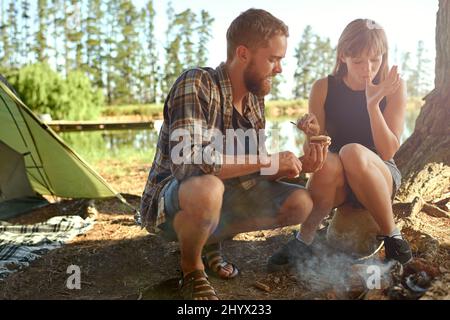 Dans les bois. Photo d'un jeune couple en train de faire des tâches pendant le camping. Banque D'Images