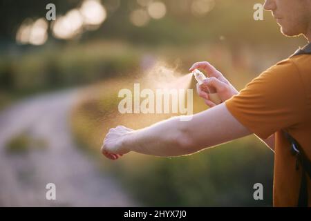 Prévention contre la piqûre de moustique dans la destination tropicale. Homme appliquant un insectifuge sur sa main. Banque D'Images