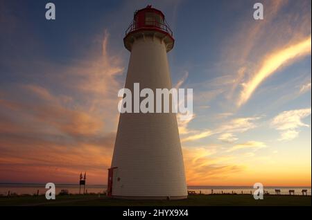 Le phare historique de point Prim à Belfast, Île-du-Prince-Édouard, vu avec des nuages de coucher de soleil en arrière-plan. Banque D'Images