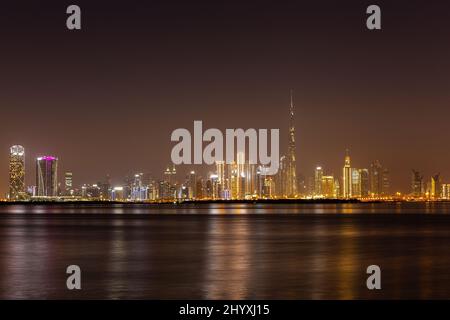 La nuit, Dubaï Business Bay offre des gratte-ciel illuminés et colorés et une eau calme de la crique de Dubaï. Banque D'Images