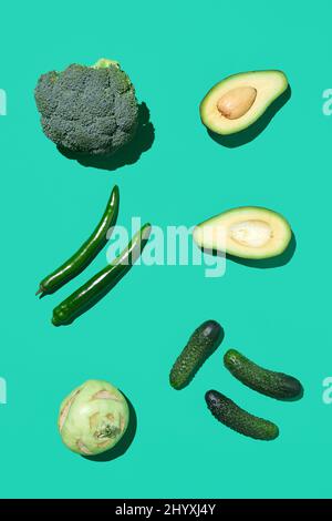 Vue minimale de dessus de la composition de légumes verts sur fond bleu clair, alimentation saine et concept vegan, copier l'espace Banque D'Images