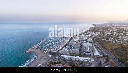 Vue aérienne par drone d'un beau coucher de soleil sur la baie de luxe Puerto Banus à Marbella, Costa del sol. Style de vie cher, yachts de luxe. Banque D'Images