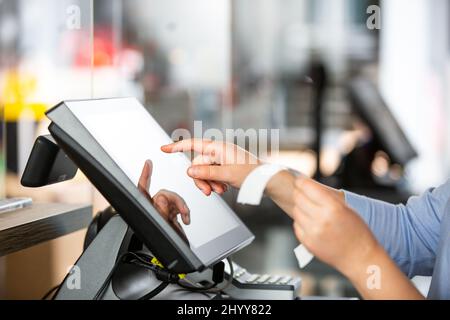 Concept de petite entreprise ou de service, femme ou femme de vente en tablier au comptoir avec caisse travaillant à la boutique de vêtements, écran tactile POS, finance concept Banque D'Images