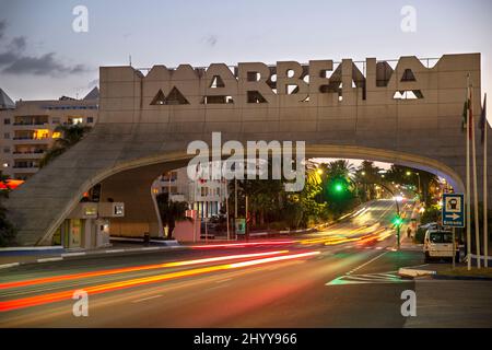 Entrée dans la ville de Marbella, panneau célèbre et emblématique, arche, perspective de nuit - illuminé dans différentes couleurs. Photographie de nuit Banque D'Images