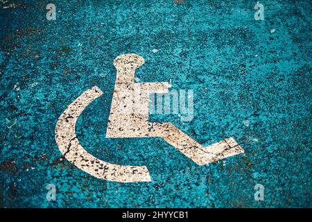 panneau de voie pour fauteuil roulant peint au sol dans une place de stationnement pour personnes à mobilité réduite. Banque D'Images