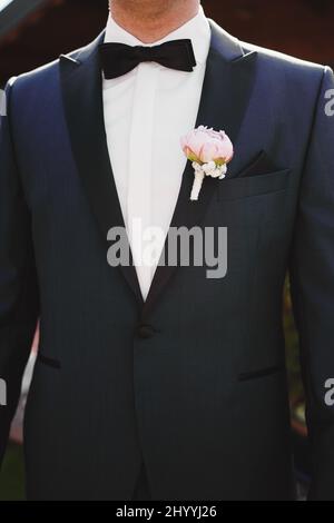 Boutonnière sur la veste du marié. Fleur sur la veste d'un homme. Un homme dans une veste avec une fleur Banque D'Images