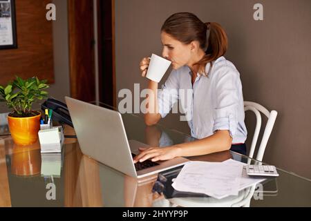 Les avantages du travail à domicile. Une jeune femme attirante qui travaille depuis son bureau à domicile. Banque D'Images