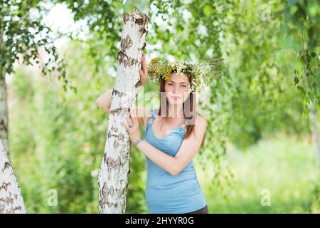 Jolie jeune femme avec une couronne de fleur sur sa tête Banque D'Images