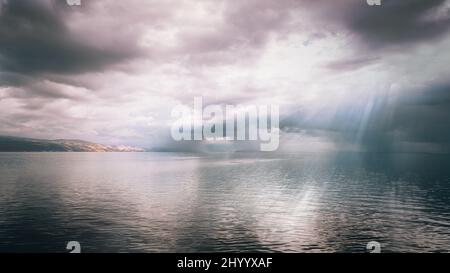 Vue panoramique du soleil se brisant à travers les nuages sur le dessus d'une mer Banque D'Images