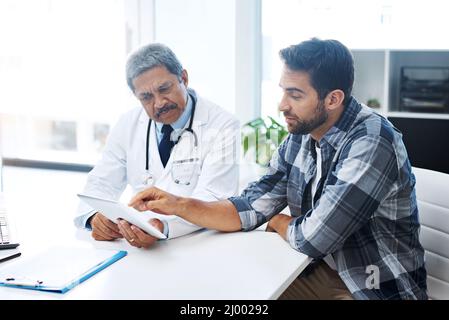 Quand avez-vous vu un médecin pour la dernière fois. Cliché d'un médecin et d'un patient hommes matures ayant une discussion au bureau des médecins avant un examen. Banque D'Images