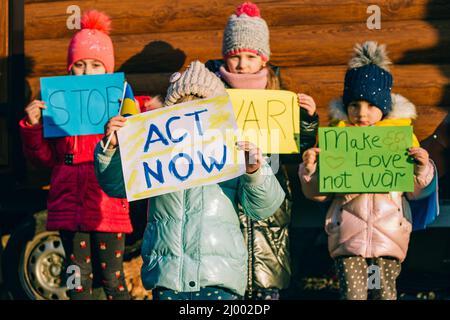 Jeunes patriotes, activistes pour enfants. Les petites filles ukrainiennes demandant d'arrêter la guerre lever bannière avec l'inscription arrêter la guerre en Ukraine Banque D'Images