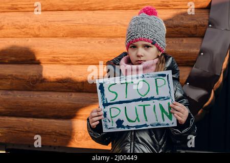 Jeunes patriotes, activistes pour enfants. Les petites filles ukrainiennes demandant d'arrêter la guerre lever bannière avec l'inscription arrêter la guerre en Ukraine Banque D'Images