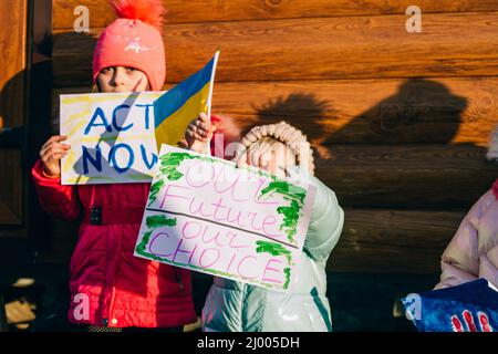 Jeunes patriotes, activistes pour enfants. Les petites filles ukrainiennes demandant d'arrêter la guerre lever bannière avec l'inscription arrêter la guerre en Ukraine Banque D'Images