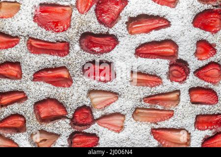 Tarte aux fraises avec des morceaux de fruits et de sucre à la surface, vue de près. Banque D'Images